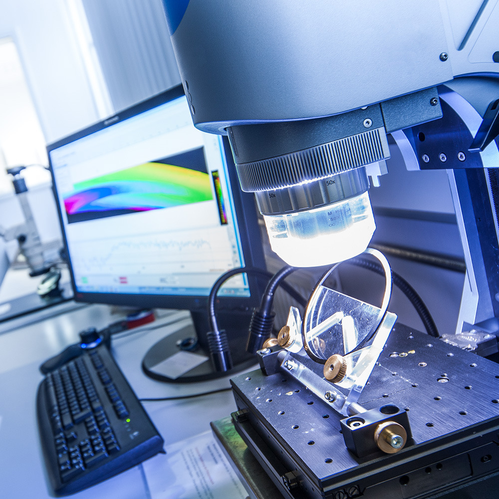 A close-up of a high-tech laboratory setup with precision instruments, a computer displaying colorful data curves.